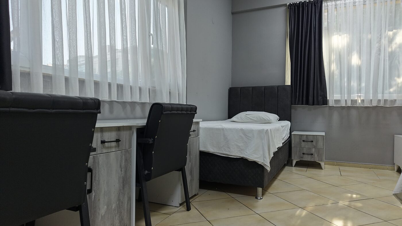 Öğrenci odası — yatak ve pencere kenarı çalışma köşesi
